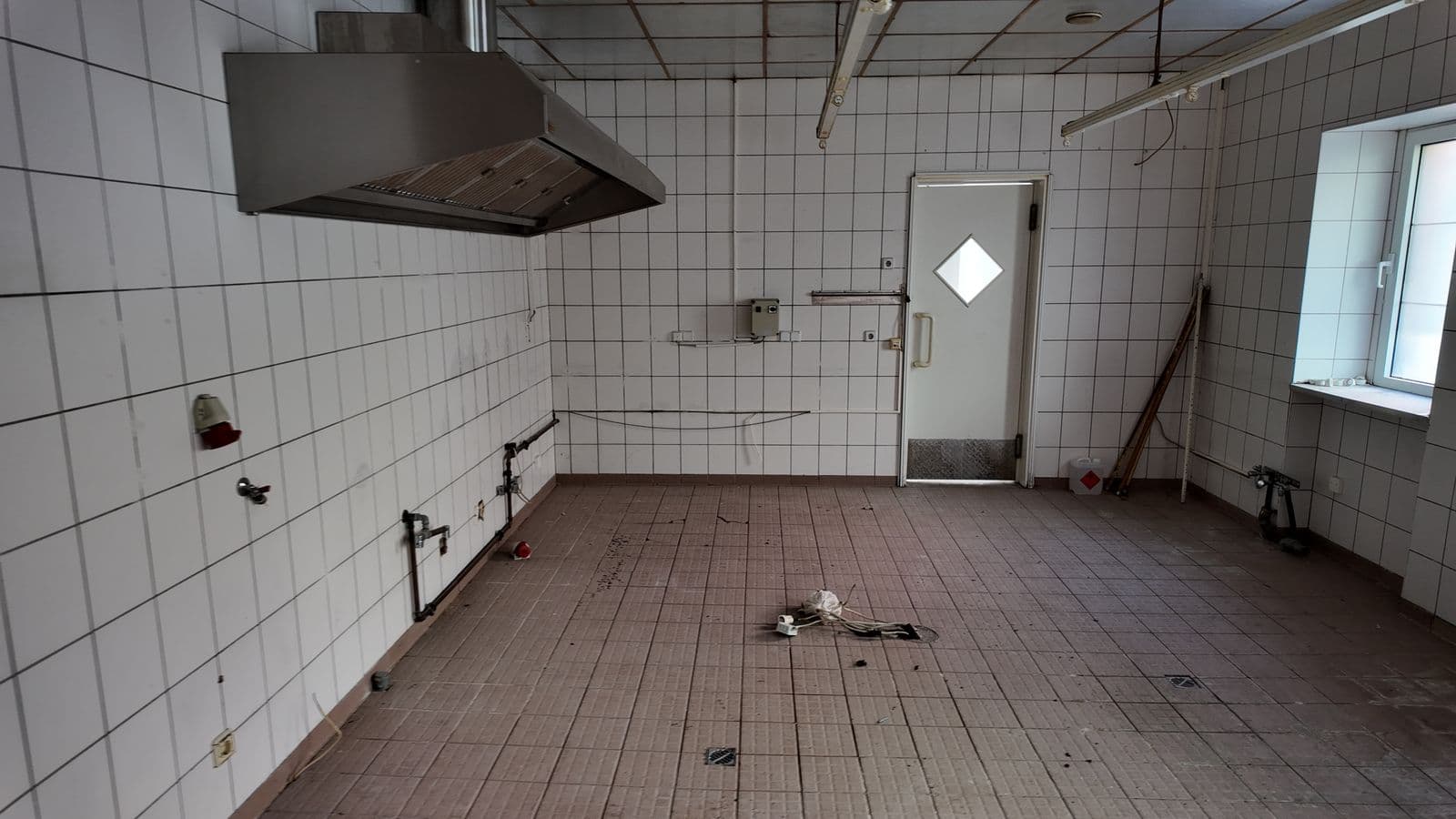 Die alte, komplett gekachelte Küche mit Dunstabzugshaube