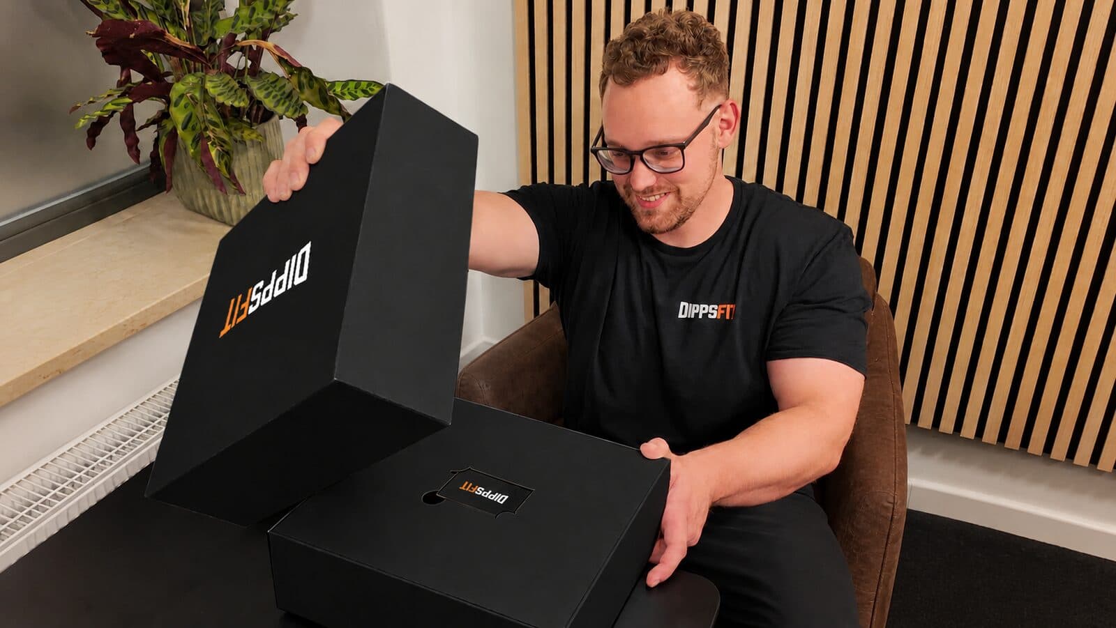 Die schwarze DippsFit-Willkommensbox wird geöffnet